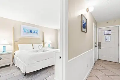 a bedroom with a large white bed and a doorway at The Summit 820 in Panama City Beach