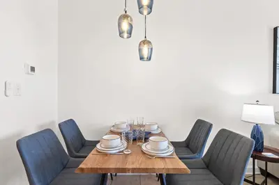 a dining room with a wooden table with blue chairs at Seychelles 1006 in Panama City Beach