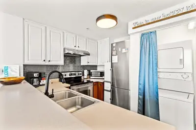 a kitchen with a sink and a stainless steel refrigerator at Seychelles 1006 in Panama City Beach