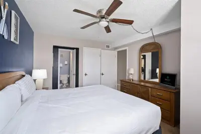 a bedroom with a white bed and a ceiling fan at The Summit 613 in Panama City Beach