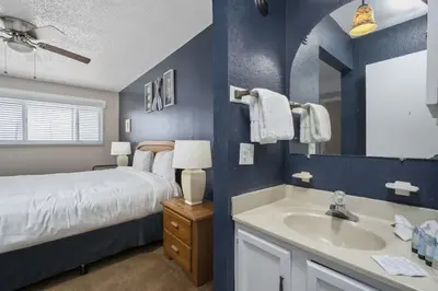 a blue bedroom with a bed and a sink at The Summit 613 in Panama City Beach