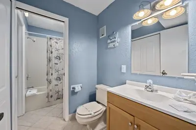 a bathroom with a sink and a toilet and a mirror at The Summit 613 in Panama City Beach