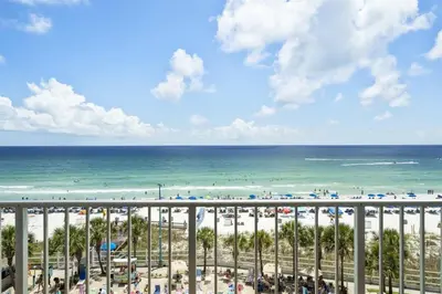 a view of the beach from the balcony of a resort at The Summit 613 in Panama City Beach