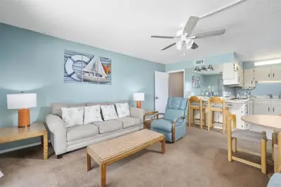 a living room with a couch and a kitchen at The Summit 613 in Panama City Beach