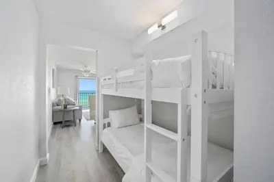 a bedroom with two bunk beds and a desk at The Summit 626 in Panama City Beach