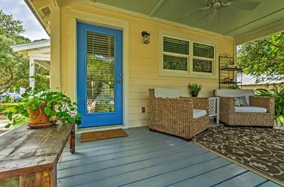 a front porch with a blue door and wicker chairs at Seagrove Beach Studio - quarter Mi to Beach Access! in Santa Rosa Beach
