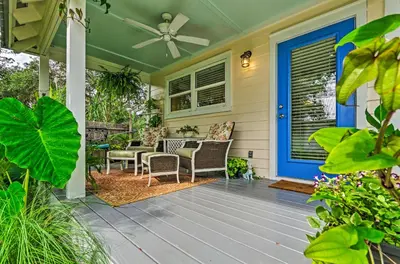 a front porch with a blue door and chairs at Seagrove Beach Studio - quarter Mi to Beach Access! in Santa Rosa Beach