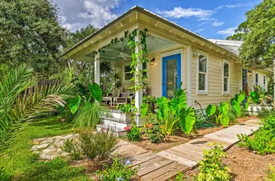 a small yellow house with a porch and plants at Seagrove Beach Studio - quarter Mi to Beach Access! in Santa Rosa Beach