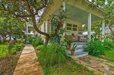 a white house with a tree on the porch at Tropical Studio quarter Mi to Public Beach Access! in Santa Rosa Beach