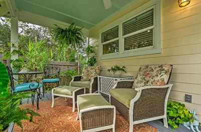 a porch with chairs and tables and a window at Tropical Studio quarter Mi to Public Beach Access! in Santa Rosa Beach