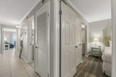 a bedroom with a door leading to a room with a bed at The Summit 1216 in Panama City Beach