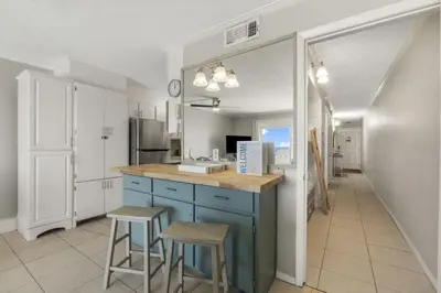 a kitchen with a blue island and two stools at The Summit 1216 in Panama City Beach