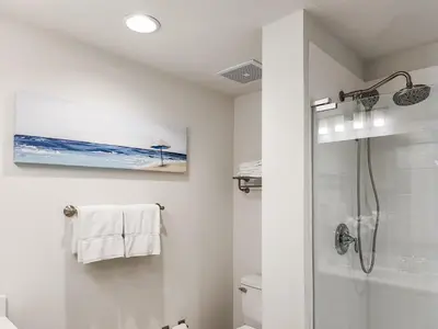 a white bathroom with a shower and a toilet at Calypso Resort and Towers #1806-3 by Book That Condo in Panama City Beach