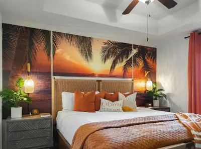 a bedroom with a bed with a palm tree mural at Calypso Resort and Towers #1806-3 by Book That Condo in Panama City Beach