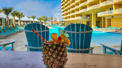 a pineapple drink on a table next to a pool at Calypso Resort and Towers #1806-3 by Book That Condo in Panama City Beach