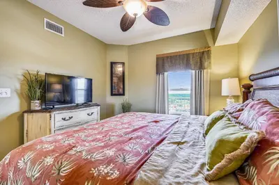 a bedroom with a bed and a flat screen tv at Majestic Beach Resort #1303-2 by Book That Condo in Panama City Beach