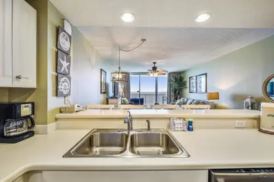 a kitchen with a sink and a view of the ocean at Majestic Beach Resort #1303-2 by Book That Condo in Panama City Beach