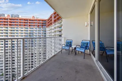 a balcony with two chairs and a table and a building at Shores of Panama #1725 at Book That Condo in Panama City Beach