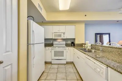 a kitchen with white appliances and a sink at Shores of Panama #1725 at Book That Condo in Panama City Beach