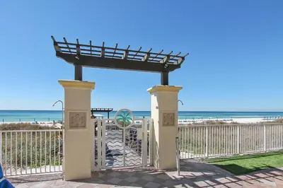 a gate at the beach with the ocean in the background at Shores of Panama #1725 at Book That Condo in Panama City Beach