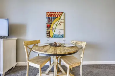 a dining room table with two chairs and a painting at Shores of Panama #1725 at Book That Condo in Panama City Beach