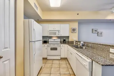 a kitchen with white appliances and a sink at Shores of Panama #1727 at Book That Condo in Panama City Beach