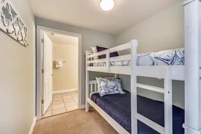 a bedroom with two bunk beds and a hallway at Shores of Panama #1727 at Book That Condo in Panama City Beach