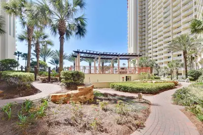a walkway in front of a building with palm trees at Shores of Panama #1727 at Book That Condo in Panama City Beach