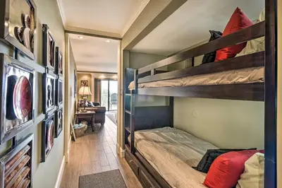 a room with two bunk beds and a desk at PCB Condo with 2 Outdoor Pools and Beach Access! in Panama City Beach