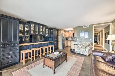 a kitchen with blue cabinets and a living room at PCB Condo with 2 Outdoor Pools and Beach Access! in Panama City Beach