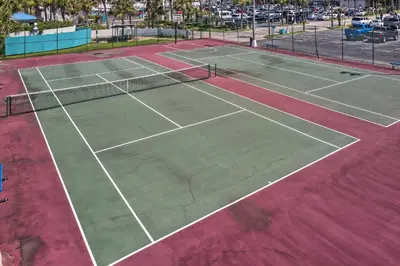 an overhead view of two tennis courts on a dirt court at PCB Condo with 2 Outdoor Pools and Beach Access! in Panama City Beach
