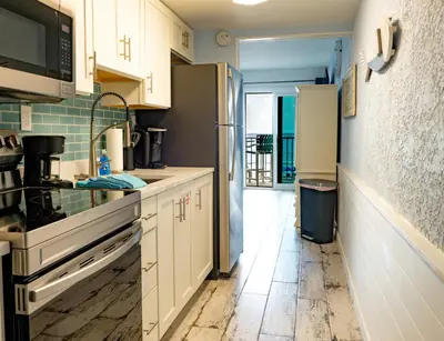 a kitchen with white cabinets and a stainless steel refrigerator at Blue Haven Villa in Panama City Beach