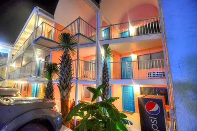 a building with colorful doors and palm trees in front of it at Blue Haven Villa in Panama City Beach