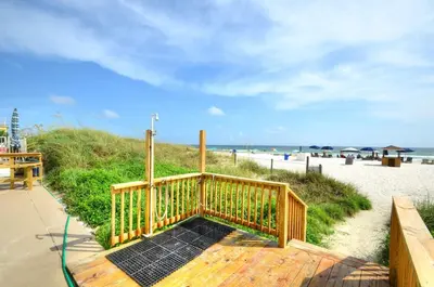 a wooden walkway leading to the beach with a boardwalk at Blue Haven Villa in Panama City Beach