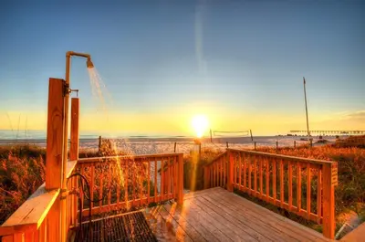a wooden walkway to the beach at sunset at Blue Haven Villa in Panama City Beach