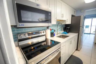 a kitchen with a stove and a microwave at Blue Haven Villa in Panama City Beach