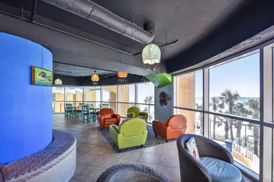 a living room with colorful chairs and a large window at Splash Beach Resort #1601-W by Book That Condo in Panama City Beach