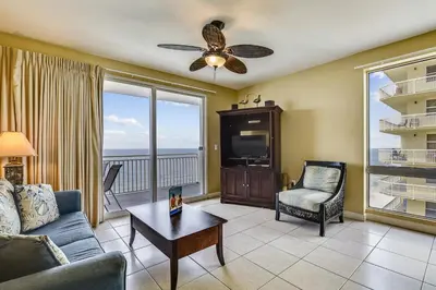 a living room with a couch and a tv at Splash Beach Resort #1601-W by Book That Condo in Panama City Beach
