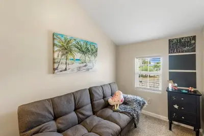 a living room with a brown couch and a dresser at Basking by the Beach in Panama City Beach