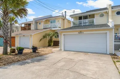 a house with a garage in front of it at Basking by the Beach in Panama City Beach
