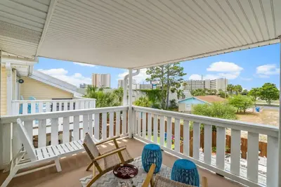 a porch with chairs and a table with a view at Basking by the Beach in Panama City Beach