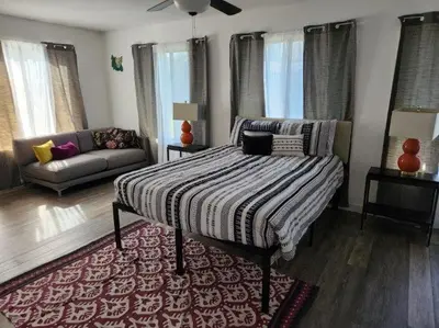 a bedroom with a bed and a couch at Peace On The Beach House in Panama City Beach