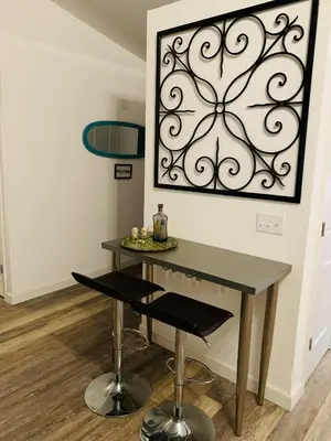 a dining room table and stool with a picture on the wall at Peace On The Beach House in Panama City Beach