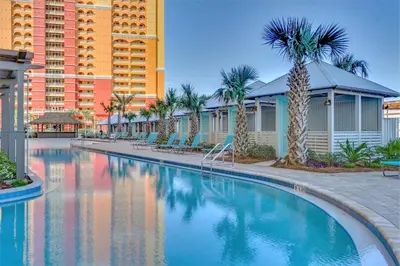a swimming pool at a resort with palm trees and buildings at Calypso Resort Tower 3 by Panhandle Getaways in Panama City Beach