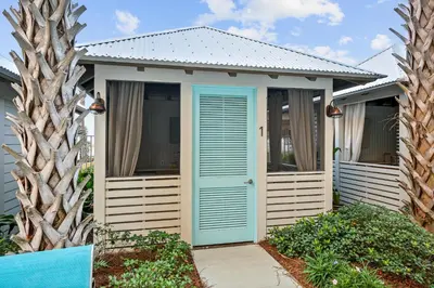 a small house with a blue door and trees at Calypso Resort Tower 3 by Panhandle Getaways in Panama City Beach