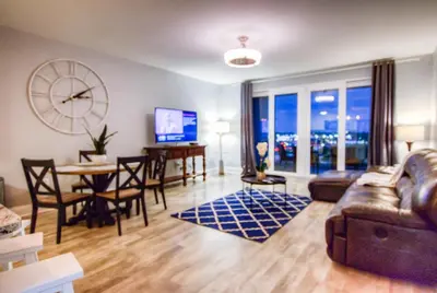 a living room with a couch and a table and a clock at BRAND NEW! Laketown Wharf 633! Amazing 3 BD, Great Location, And Awesome Amenities! in Panama City Beach