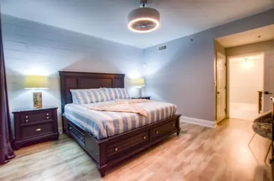 a bedroom with a bed and a night stand with a lamp at BRAND NEW! Laketown Wharf 633! Amazing 3 BD, Great Location, And Awesome Amenities! in Panama City Beach