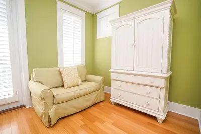 a bedroom with a dresser and a chair next to a cabinet at 30A Beach House - Sunny Daze by Panhandle Getaways in Panama City Beach