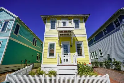 a yellow house in between two colorful houses at 30A Beach House - Sunny Daze by Panhandle Getaways in Panama City Beach