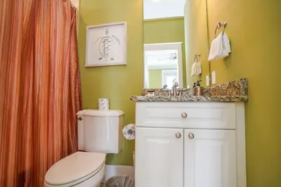 a bathroom with a toilet and a sink and a mirror at 30A Beach House - Sunny Daze by Panhandle Getaways in Panama City Beach